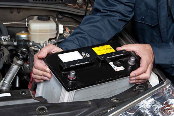 auto mechanic replacing car battery